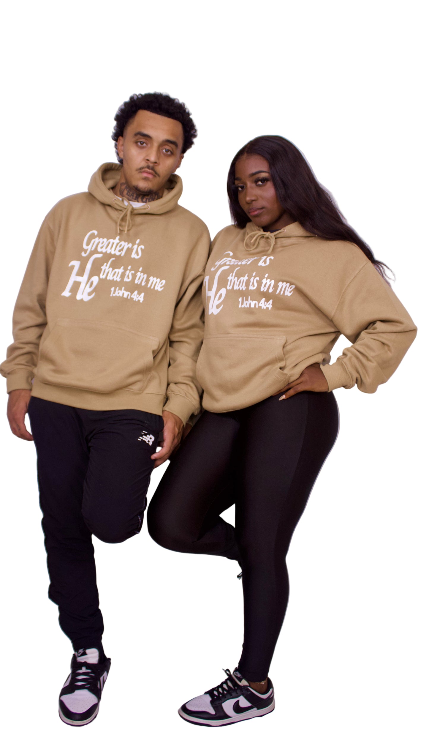 Two people wearing matching light brown hoodies with text on a plain background
