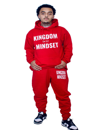Person wearing a red 'Kingdom Mindset' tracksuit on a white background