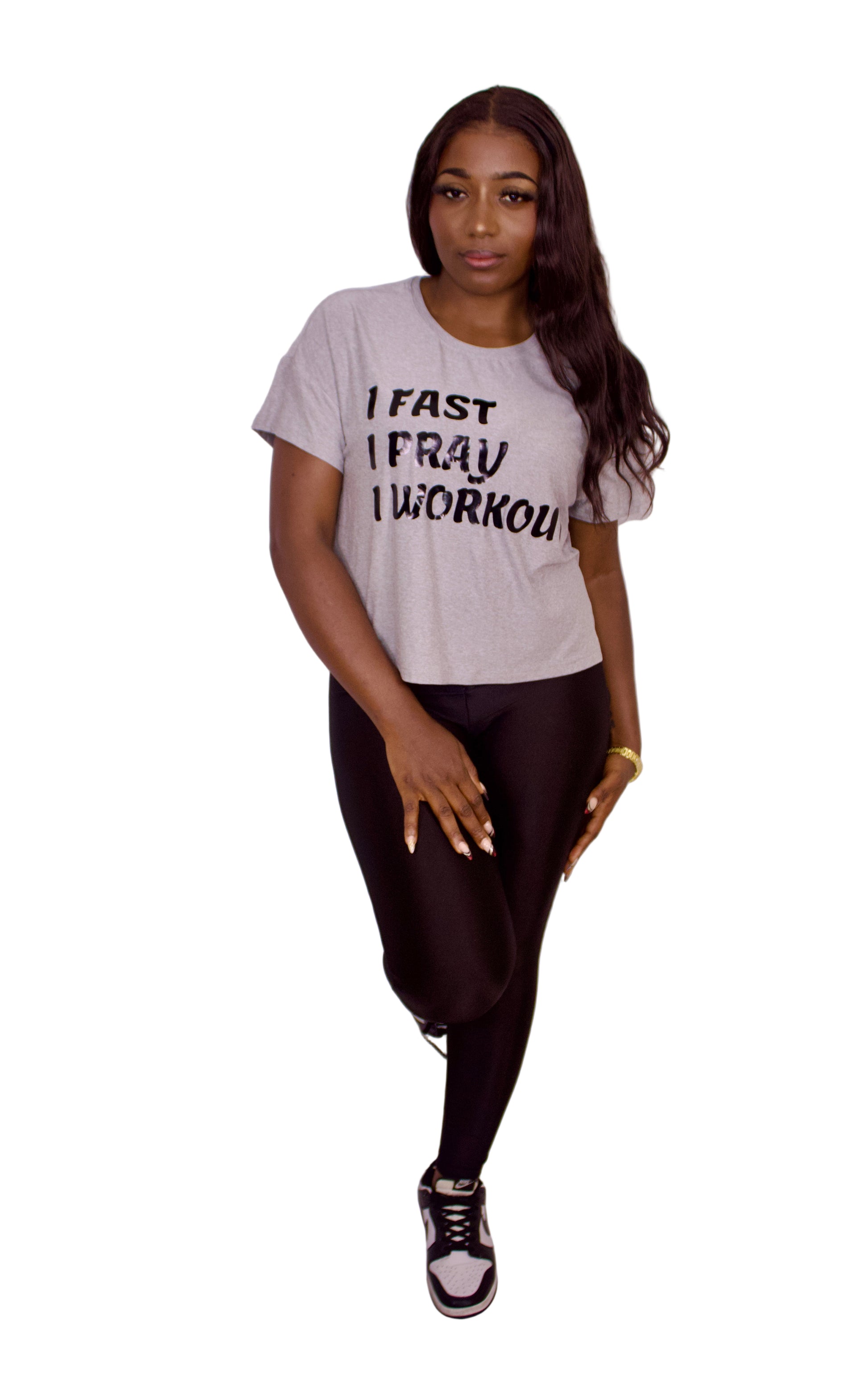 Woman wearing a gray t-shirt with text on a plain background