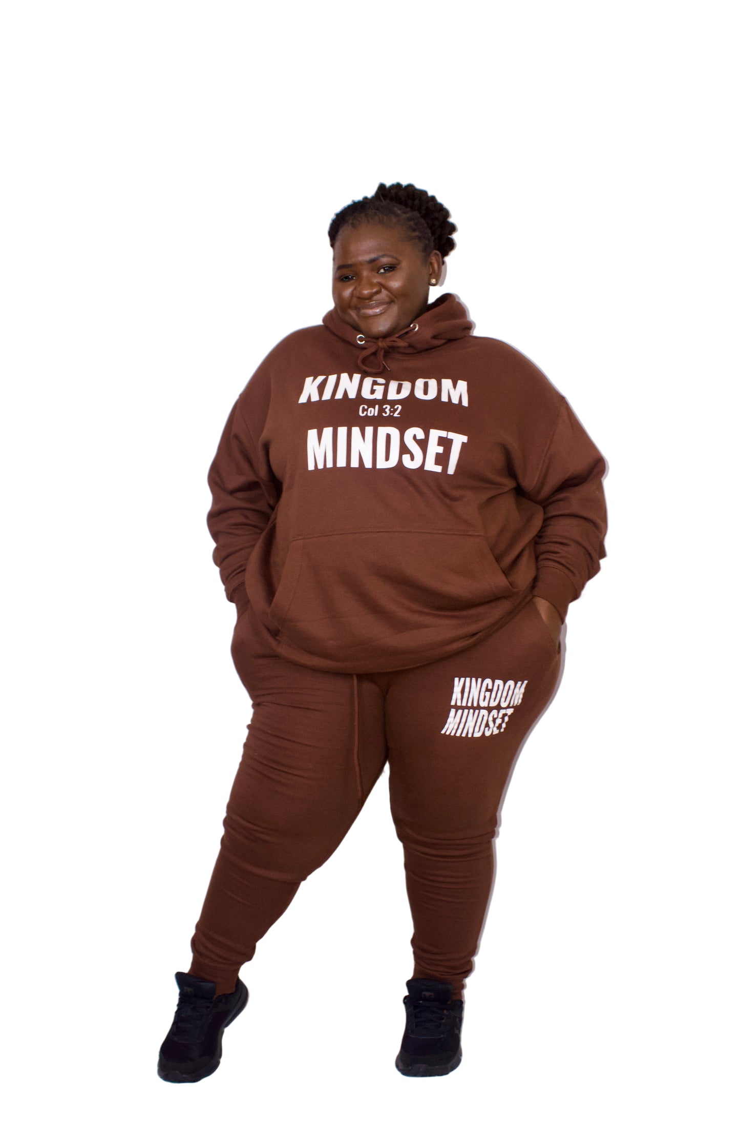 Person wearing a brown 'Kingdom Mindset' hoodie and pants on a white background