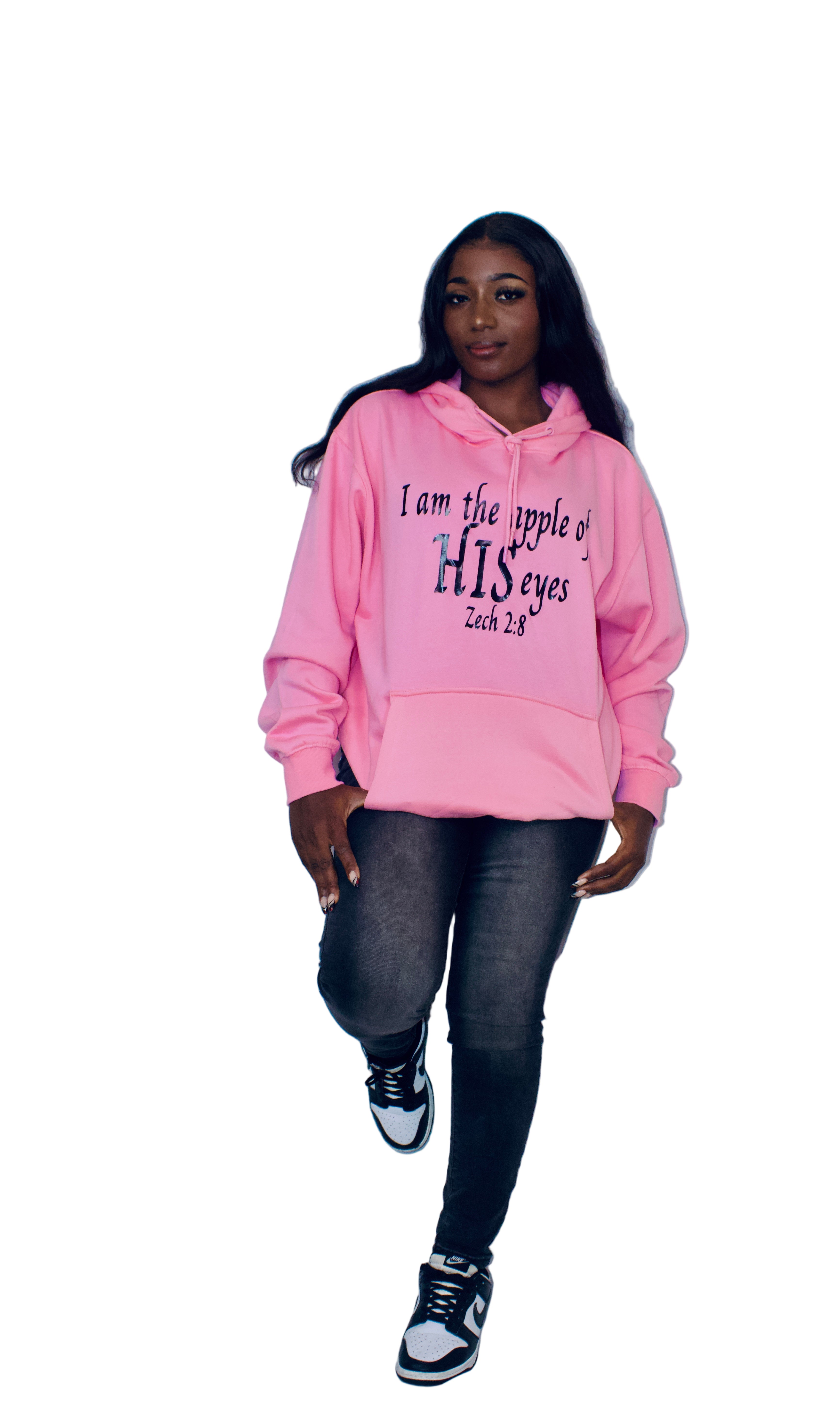 Person wearing a pink hoodie with text, standing against a plain background
