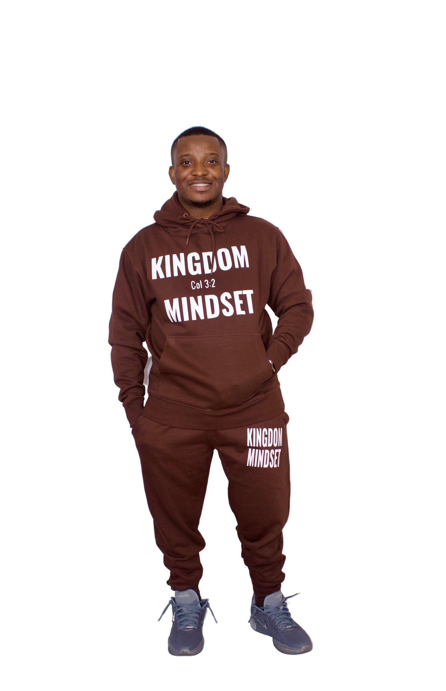 Person wearing a brown 'Kingdom Mindset' hoodie and pants on a white background